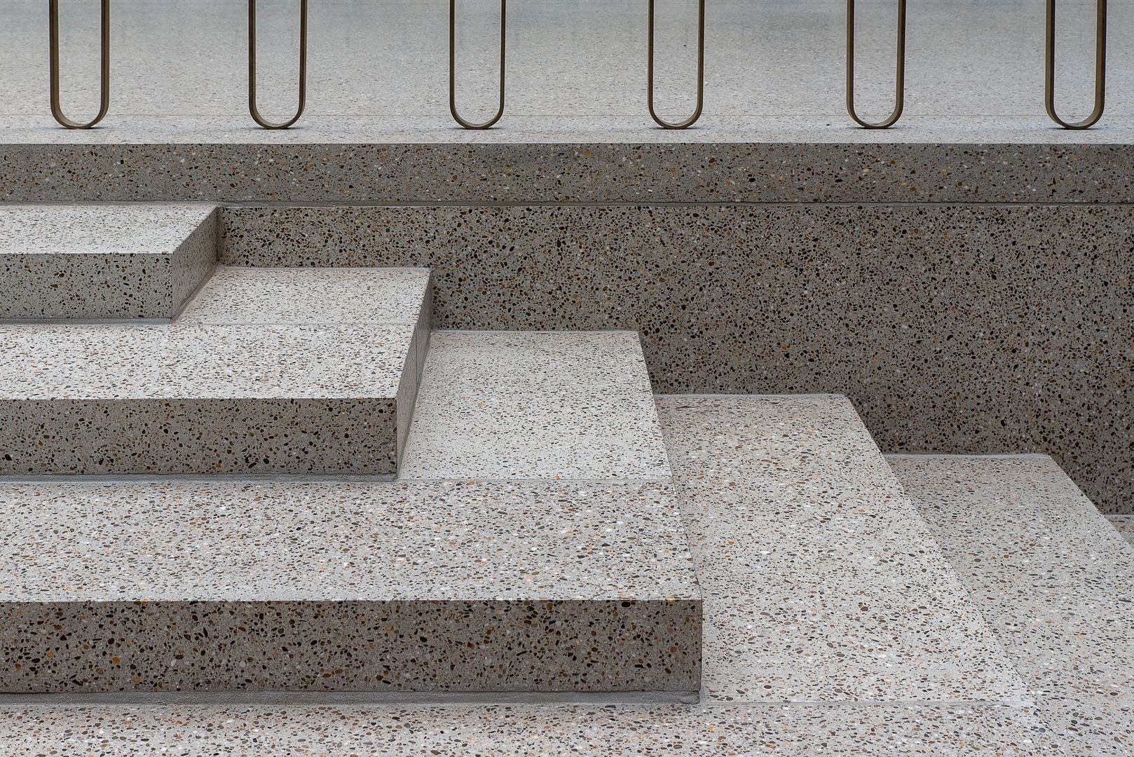 Gestufte Sitzstufen aus geschliffenem Terrazzo mit Metallbügeln