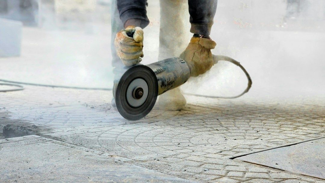 Handwerker schleift einen mineralischen Boden mit einer Betonschleifmaschine
